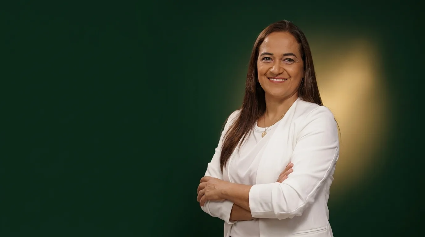 Dra. Sidnéia Ribeiro, de blazer branco e braços cruzados, sorrindo